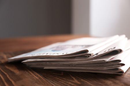 Pile of newspapers on wooden table