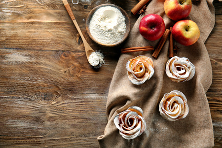 Tasty apple roses from puff pastry on wooden tableの写真素材