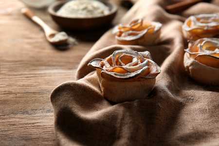 Tasty apple roses from puff pastry on wooden tableの写真素材