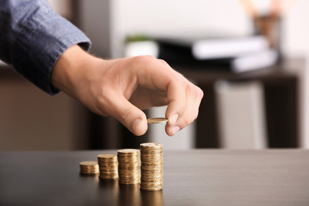 Man stacking coins on table. Savings conceptの写真素材