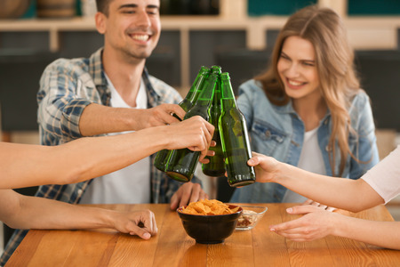 Group of cheerful friends drinking beer in barの写真素材