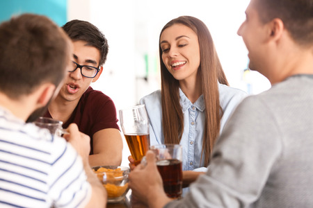 Group of cheerful friends drinking beer in barの写真素材