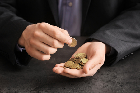 Man counting coins at table. Savings conceptの写真素材