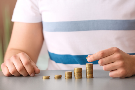 Man stacking coins on table. Savings conceptの写真素材