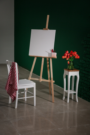 Easel with canvas and chair in artist's workshopの写真素材