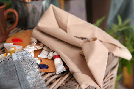 Tubes with paints and palette on wicker basket in artist's workshopの写真素材