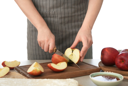 Woman cutting apples for pastry on wooden boardの写真素材