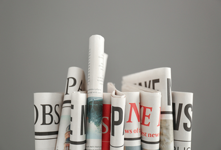 Folded newspapers on grey background