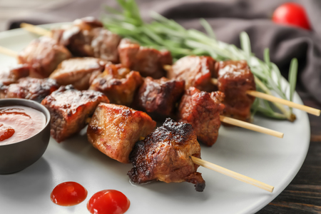 Barbecue skewers with juicy meat and sauce on plate, closeupの写真素材