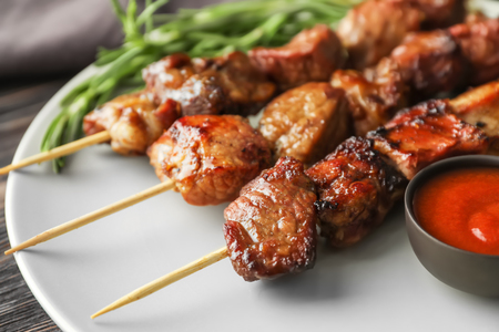 Barbecue skewers with juicy meat and sauce on plate, closeupの写真素材