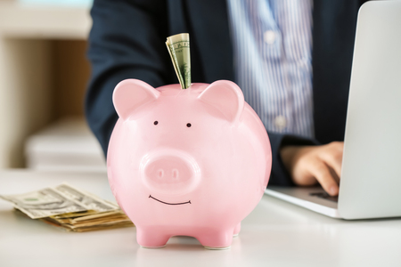 Piggy bank with money on table. Savings conceptの写真素材