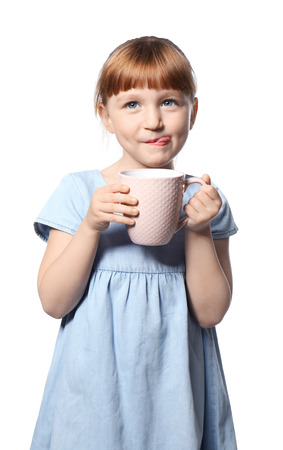 Cute little girl with cup of hot cocoa drink on white backgroundの写真素材