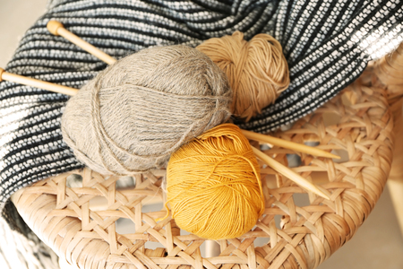 Knitting yarn with needles and plaid on chairの写真素材