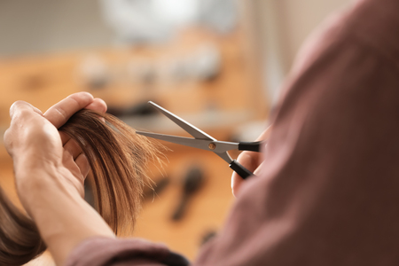 Professional hairdresser working with client in beauty salon, closeupの写真素材