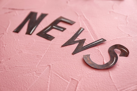 Word NEWS made of letters on color textured background