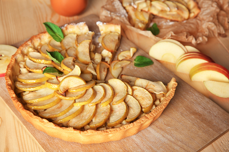 Wooden board with tasty homemade apple pie on tableの写真素材