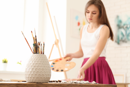 Set of brushes on table in female artist's workshopの写真素材