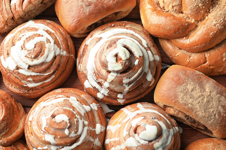 Sweet cinnamon buns on table, top view