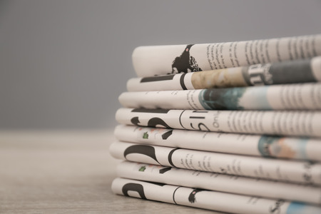 Pile of various newspapers on tableの写真素材