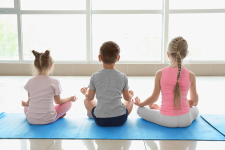 Little children practicing yoga indoorsの写真素材