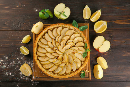 Composition with tasty homemade apple pie and fruits on wooden backgroundの写真素材
