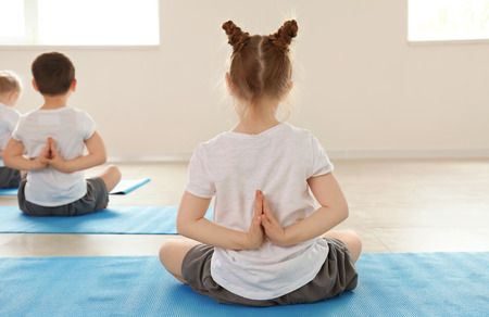 Little children practicing yoga indoorsの写真素材