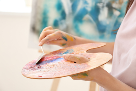 Female artist painting picture in workshop, closeupの写真素材