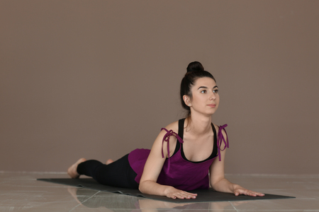 Young woman practicing yoga near color wallの写真素材