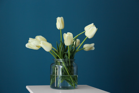 Vase with beautiful tulips on color backgroundの写真素材