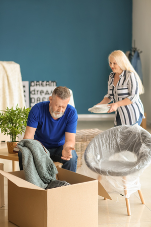 Mature couple unpacking moving box at new homeの写真素材