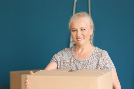 Mature woman with moving box at new homeの写真素材