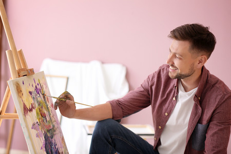 Male artist painting in workshopの写真素材