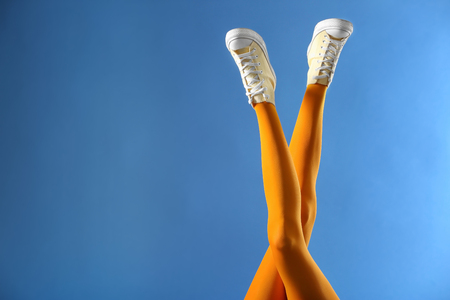 Legs of beautiful young woman in tights on color backgroundの写真素材