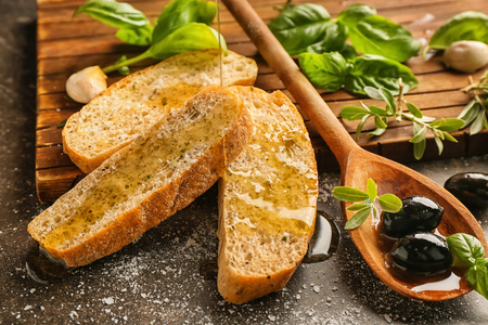 Olive oil with bread and herbs on tableの写真素材