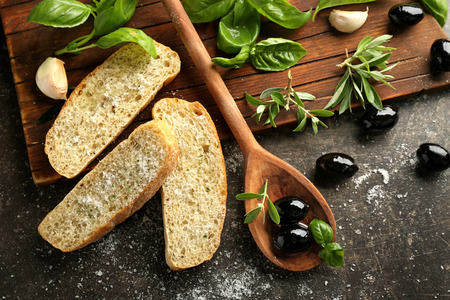Composition with black olives, spices and bread on dark backgroundの写真素材