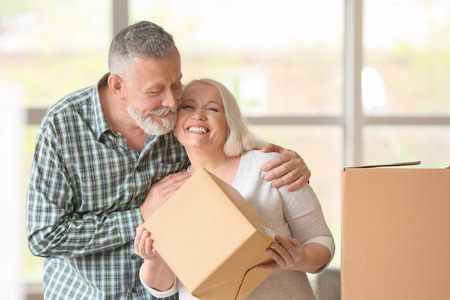 Mature couple with moving boxes at new homeの写真素材