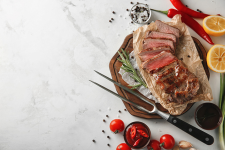 Composition with tasty grilled steak on light backgroundの写真素材
