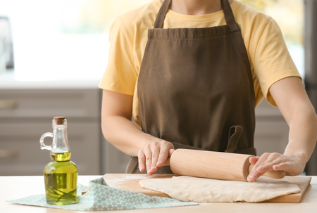 Woman rolling dough on kitchen tableの写真素材