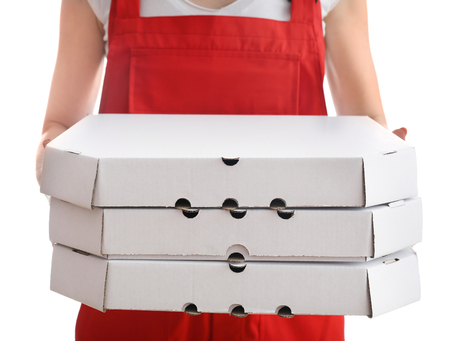 Delivery woman with cardboard pizza boxes on white backgroundの写真素材