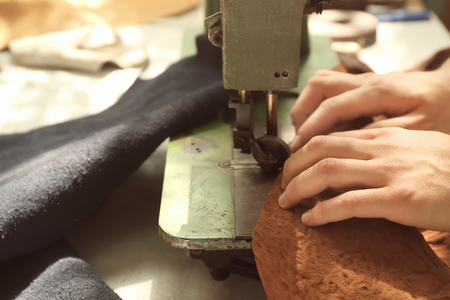 Man using sewing machine in leather workshop