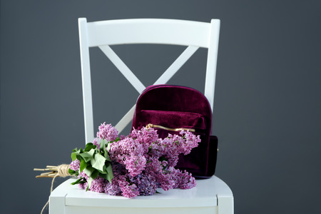 Chair with beautiful blossoming lilac on color backgroundの写真素材