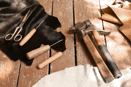 Set of leather working tools on table in workshopの写真素材