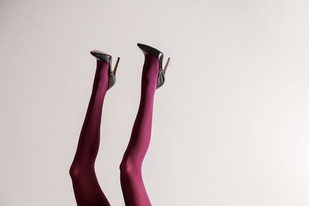 Legs of beautiful young woman in color tights on light backgroundの写真素材