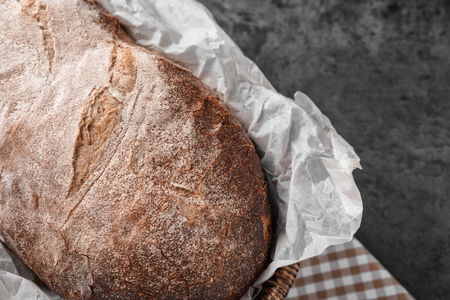 Basket with tasty fresh bread on table, closeup