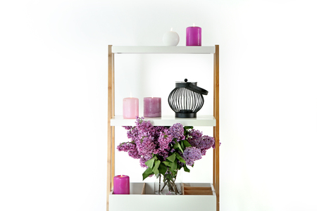 Shelf with beautiful blossoming lilac and candles on white backgroundの写真素材