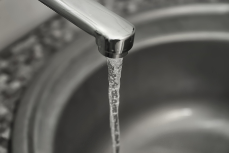 Water pouring from tap, closeup. Water saving conceptの写真素材