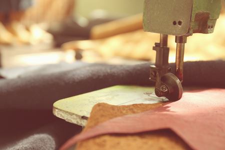 Sewing machine with leather on table, closeup