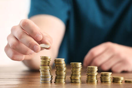 Man stacking coins on table. Savings concept