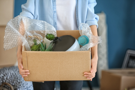 Woman with packed carton box indoors. Moving house conceptの写真素材