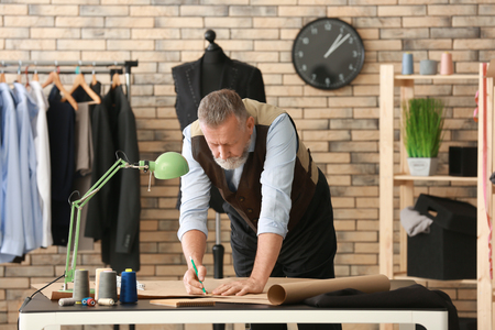 Mature tailor working with sewing pattern in atelierの写真素材